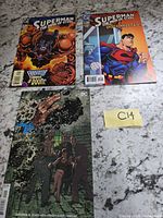 All three comics laid out on countertop with lot tag C14 visible