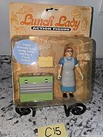 Front view of sealed Lunch Lady action figure package showing figure and accessories