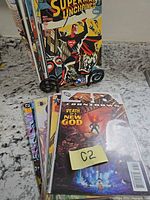 Front view of stacked comic books showing Superman Unchained, Countdown: Death of the New Gods and additional issues