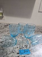 Five blue bubble glass goblets grouped on countertop