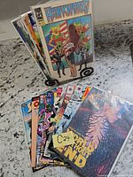 Overall lot showing all fifteen bagged and boarded comics with Hawkworld and World Without End visible