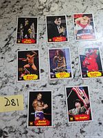 Eight WWE trading cards laid out on countertop with D81 note visible