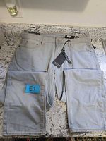 Front view of jeans showing tags, size, color and condition