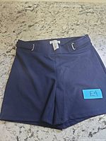Front view of navy shorts on countertop, blue E4 sticker visible