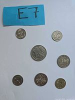 Obverse sides of seven coins with lot tag