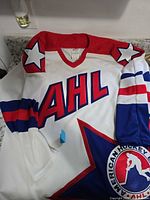 Front view of white CCM AHL jersey showing chest lettering and shoulder star design
