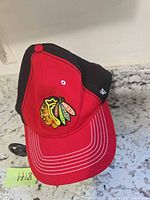 Front view of red and black cap showing embroidered Blackhawks logo and ’47 side logo