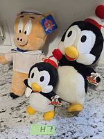 Group shot of Porky Pig plush and two Chilly Willy plush with tags visible