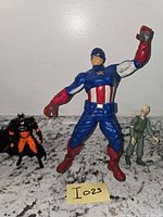 All three action figures standing with lot tag I023
