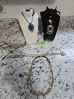 Group shot of all six necklaces displayed on stands and countertop