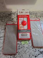 Front view of Duop pad holder package flanked by two microfiber pad packages