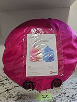 Front view of folded pink carry case displaying product sheet for KidSquad Regal Castle pop-up tent