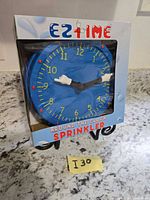 Front of sealed retail box showing blue clock-shaped sprinkler