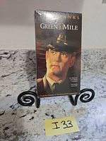 Front view of sealed The Green Mile dual VHS set on stand