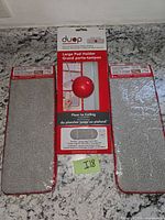 Packaged Duop pad holder flanked by two grey microfiber pads