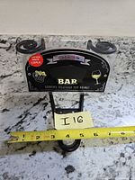 front view of bar sign with ruler for scale