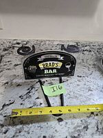 Front view of sign with tape measure showing width