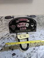 Front view of packaged sign showing design and measuring tape for scale