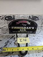 Front view of sign in packaging with measurement tape indicating width