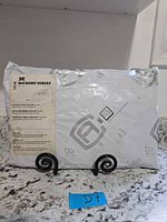 Sealed plastic package of Hickory Series grill top cover front view