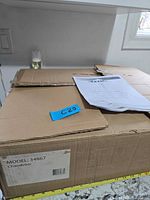 Sealed box labeled Model 34867 chandelier with manual on top