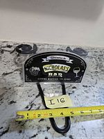 Front view of personalized bar sign on metal hanger with ruler for scale