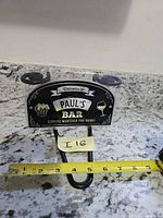 Front of sign showing text, suction cups, hook, tape measure for width