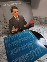 Front jacket of Gary Numan The Pleasure Principle LP on stand with lyric sleeve and record visible