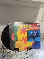 Front of picture sleeve with vinyl partially exposed showing red Columbia label