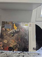 Album front cover, sleeve, and black vinyl partially visible