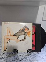 Front cover showing Vargas artwork on The Cars Candy-O jacket with vinyl partially visible