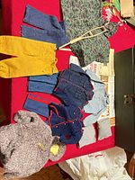 Overview of all clothing, manuals and crutch on red surface