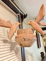 Close-up of two carved coconut shell birds and bowl