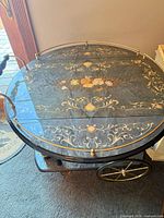 Top view showing floral marquetry, brass rail and lacquered finish