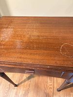 Closed wooden cabinet top showing scratches and water rings