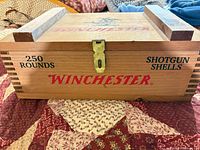 Front view showing Winchester logo, 250 Rounds, Shotgun Shells text, latch, wood runners