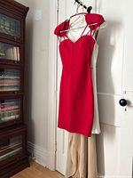 Red Guess dress front view hanging on door