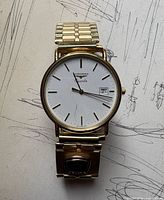 Front view of Longines gold-tone wristwatch on sketch background