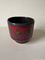 planter front showing red glaze and decorative band