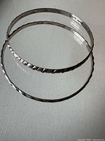 Two sterling silver bangles laying flat