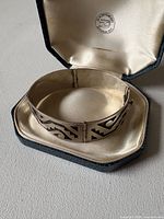 Bracelet inside fitted presentation box showing Aztec motif and box interior logo