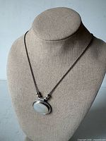 Necklace displayed on bust showing pendant front and chain