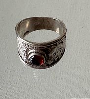 Front view of wide hammered sterling band with red cabochon stone