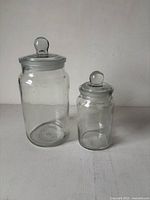 Two clear glass apothecary jars side by side