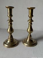 full view of both brass candlesticks standing upright