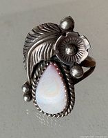 Front view showing mother of pearl cabochon and sterling feather, flower and bead detailing