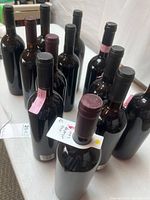 Group of 13 unlabeled wine bottles on table