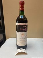 Full bottle front view showing label artwork and detached lower label piece