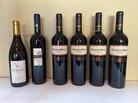 All six wine bottles standing upright