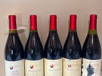 Front view of five Wilhelm Walch Pinot Nero bottles with red capsules